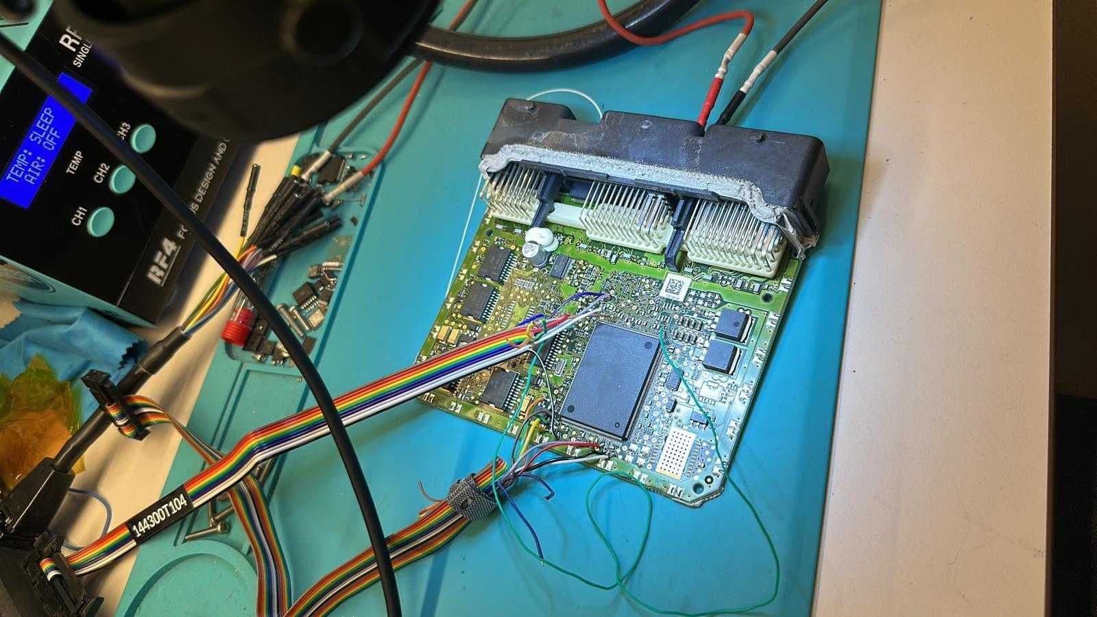 Calculator deschis pe banc, cu cablul de citire a memoriei conectat